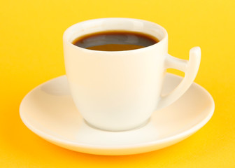 Cup of strong coffee on yellow background