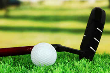 Golf ball and driver on green grass outdoor close up