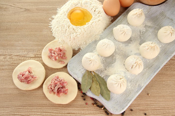 Raw dumplings, ingredients and dough, on wooden table