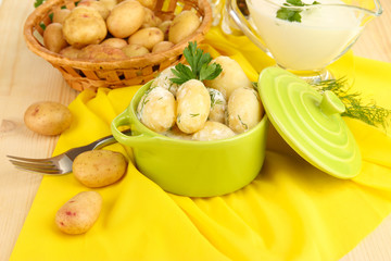 Tender young potatoes with sour cream and herbs in pan