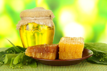 Jar of honey and honeycombs with flowers of lime,