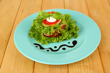 Tasty roasted marrow and tomato slices with salad leaves,