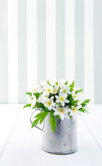 Flowers in a metal cup on vintage background