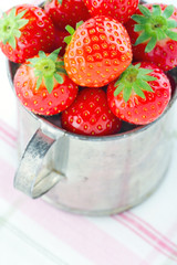 Fresh red strawberries in an old cup