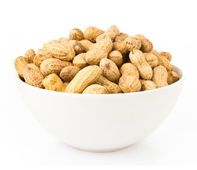 Raw shelled great peanuts in a bowl on white background, closeup