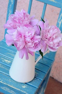 Bunch of peony on shabby blue chair