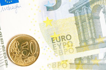 euro coin on new five euro banknote