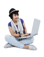 Smiling young woman using a laptop, isolated on white