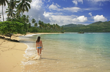 Young woman in bikini walking at Rincon beach, Samana peninsula