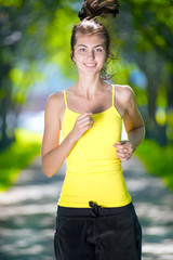 Runner - woman running outdoors in green park