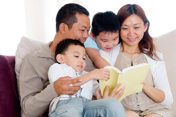 Asian family sharing a book