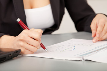 person's hand signing an important document 