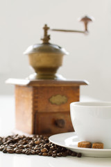 Cup of coffee with sugar and grinder