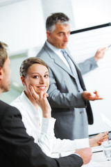 Fototapeta premium Smiling woman sitting at a business meeting with colleagues