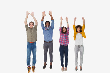 Obraz premium Four stylish friends smiling at the camera and jumping