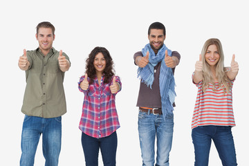 Fototapeta premium Fashionable friends looking at camera and giving thumbs up