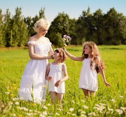 Mother and daughters relaxing on the meadow