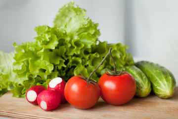 tasty tomatos, cucumbers, radish and salad on the kitchen