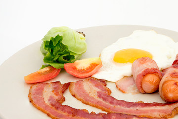 Bacon ham egg and green salad on dish isolated on white