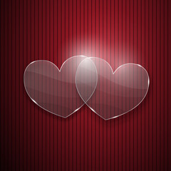 Two hearts from glass on red striped background