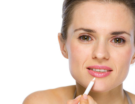 Beauty portrait of young woman applying white eye liner