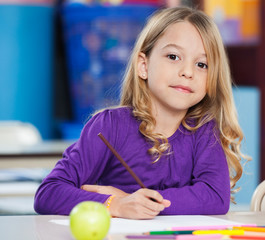 Cute Girl With Sketch Pen And Paper At Desk