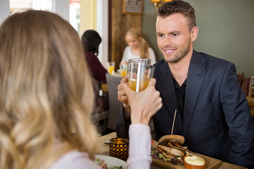 Businessman Toasting Juice Glasses With Female Colleague