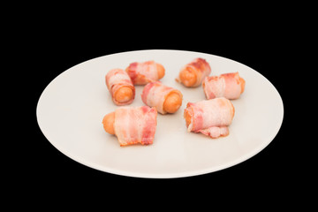 Bacon ham sausage on dish isolated on black