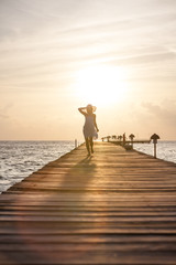 Caucasian woman takes rest at wooden pier to Indian ocean