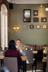 Fototapeta premium Happy Young Woman Having Coffee With Friend