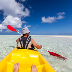 Young caucasian man kayaking in sea at Maldives