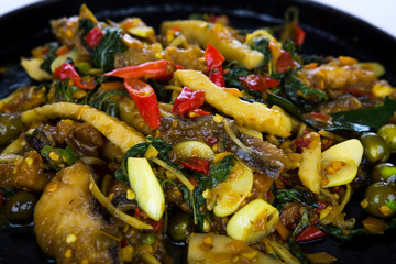 Fried fish with fresh herbs and  spicy sauce served on iron hot