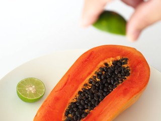 Papaya and hand squeezing lime