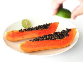 Papaya and hand squeezing lime