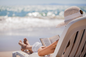 Woman relaxing and reading at the beach