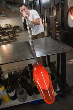 Man Blowing into Glass Object