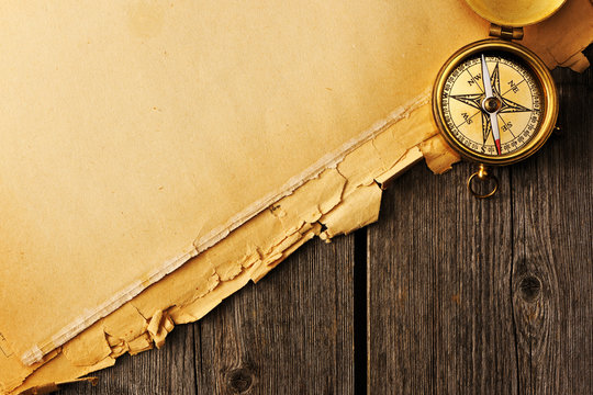 Antique brass compass over old background