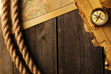 Antique compass and rope over old map