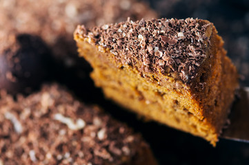 Slice of a chocolate cake raised up. Close up shot.
