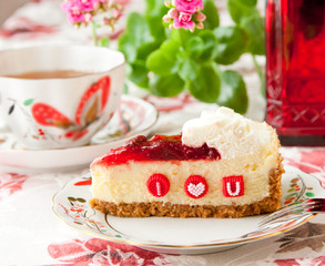 Piece of strawberry cheesecake with edible letters for Valentine
