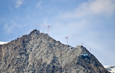 Fototapeta na wymiar Cranes building on top of mountain