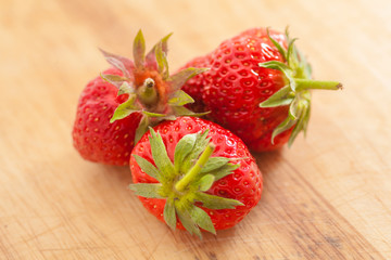 three strawberries on wooden table