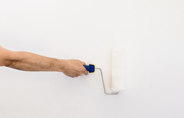 Closeup of a hand with paint roller with space copy