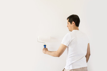 Back side view of a men painting a wall