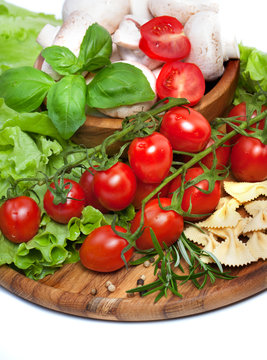 Fresh cherry tomatoes and salad in a wooden plate