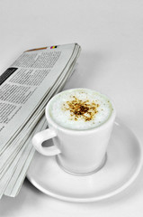 Café capuchino y periódico