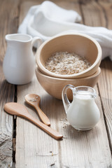 Wooden bowls and a small jug on the wooden background