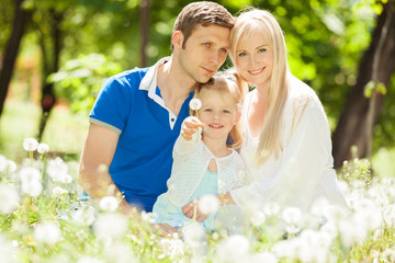 Happy mother, father and daughter in the park