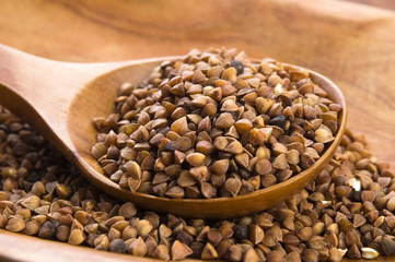 Buckwheat seeds on wooden spoon in closeup