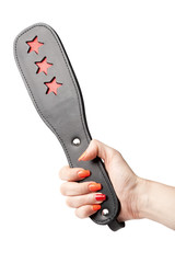 black leather fetish paddle in female hand isolated on white bac